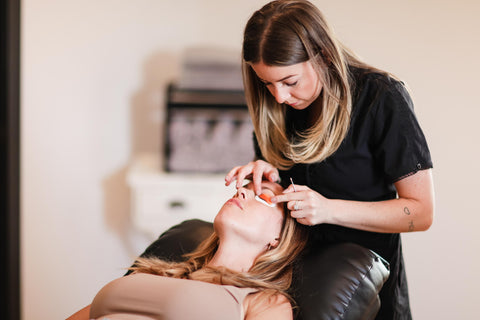 Person applying eye pads to customer for a lash lift