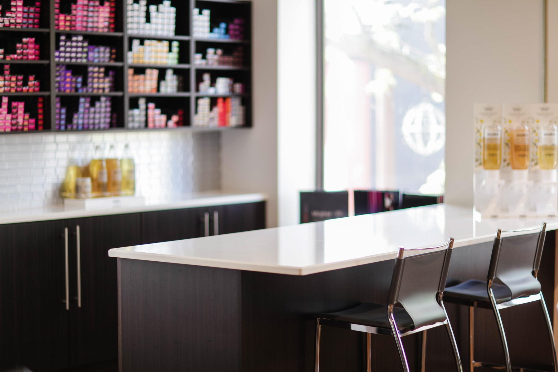 Interior of Pure Organic Spa; bar stools at table with hair colour in the background